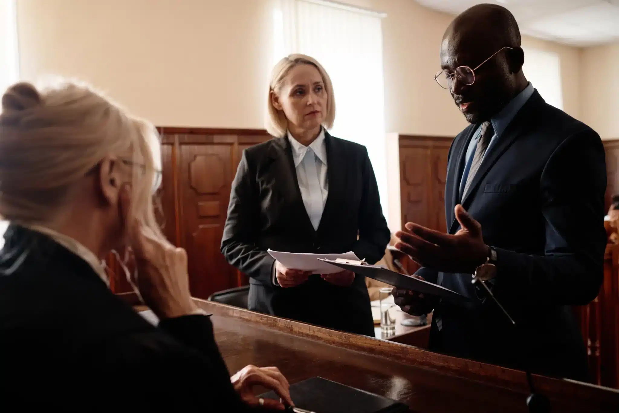 Defense and prosecution side of a case standing in front of a judge