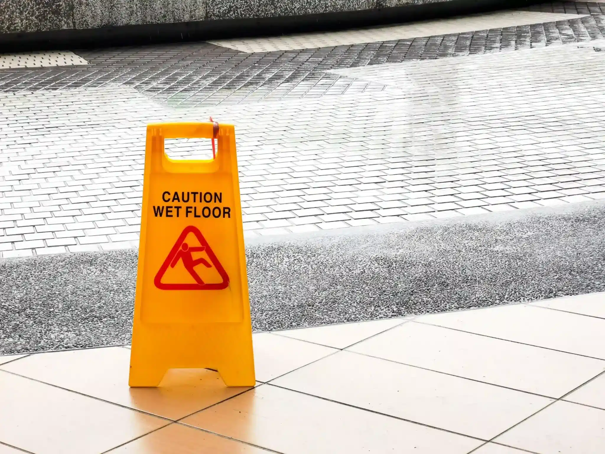 Wet floor caution sign post at the entrance of a building
