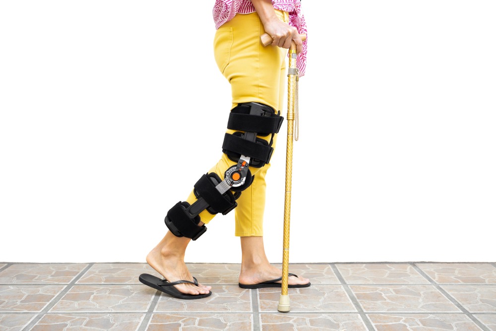 woman with a leg injury walking with a cane