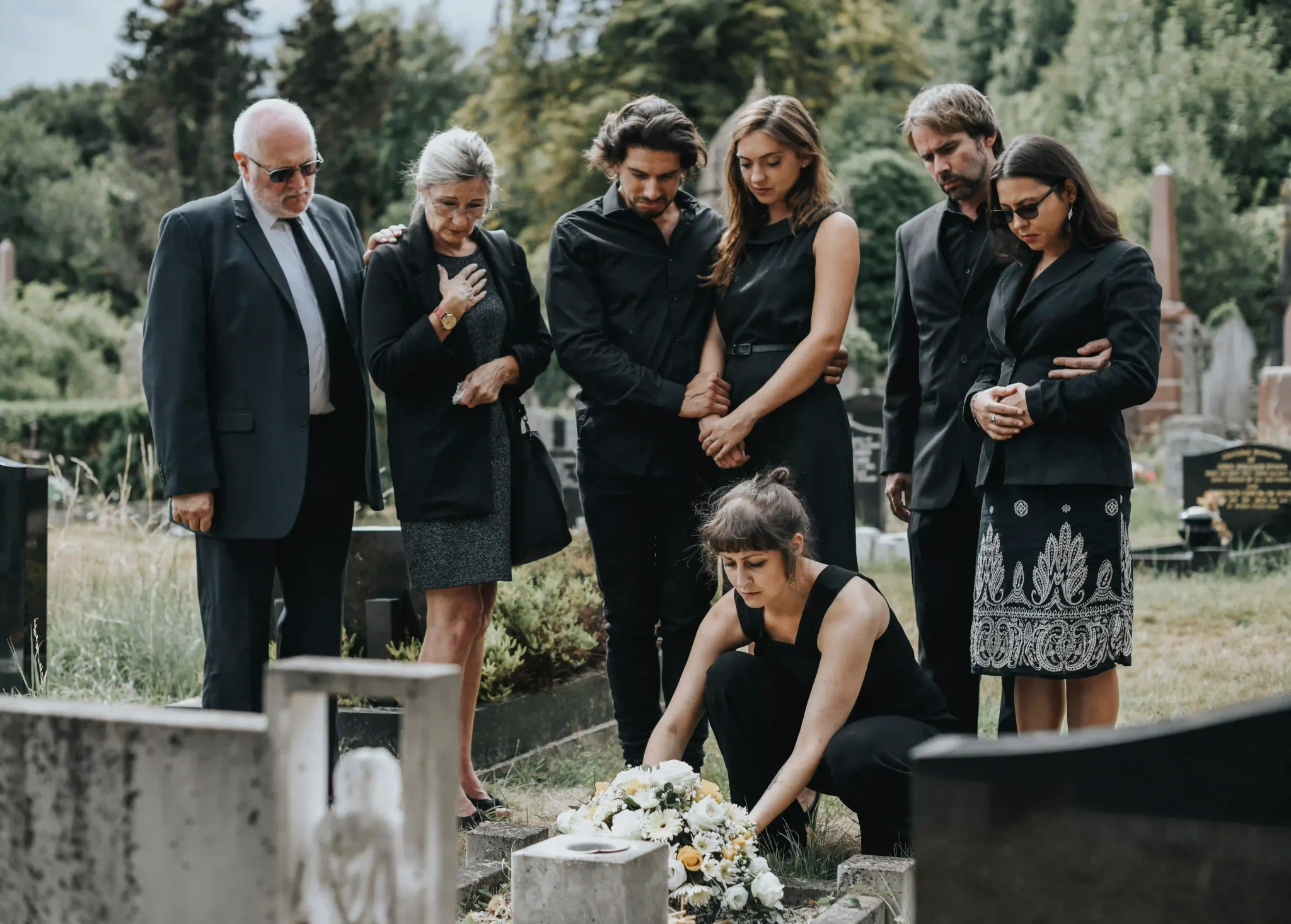 Group of family members laying flowers on a grave