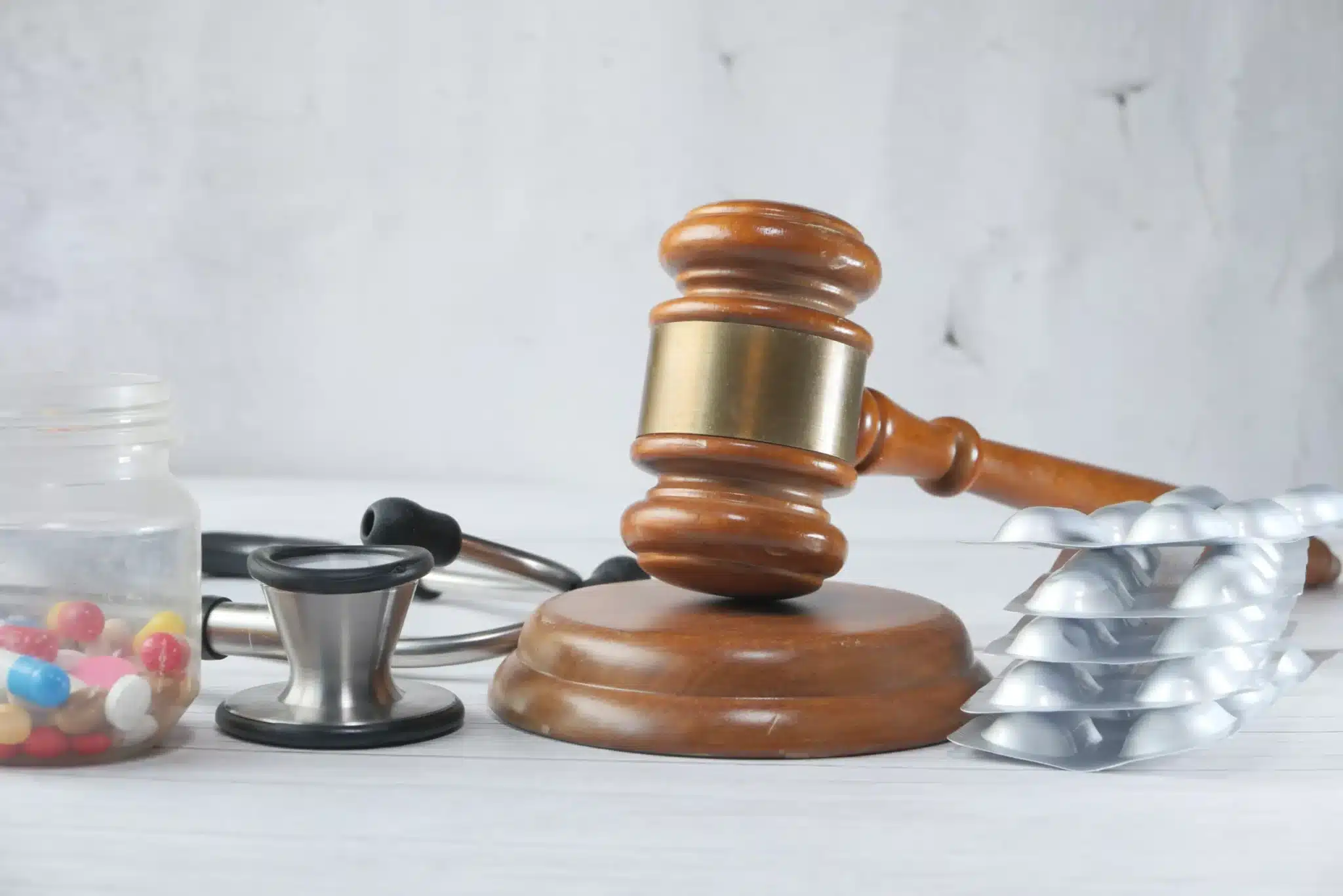 Judge gavel, stethoscope and pills on the table