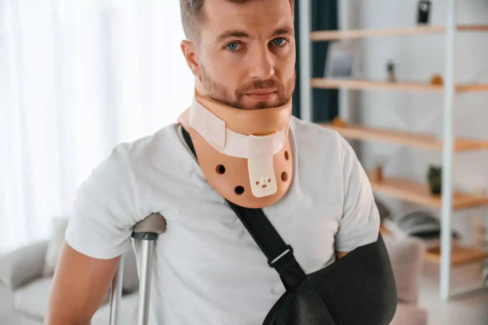 Injured man with broken arm and crutches