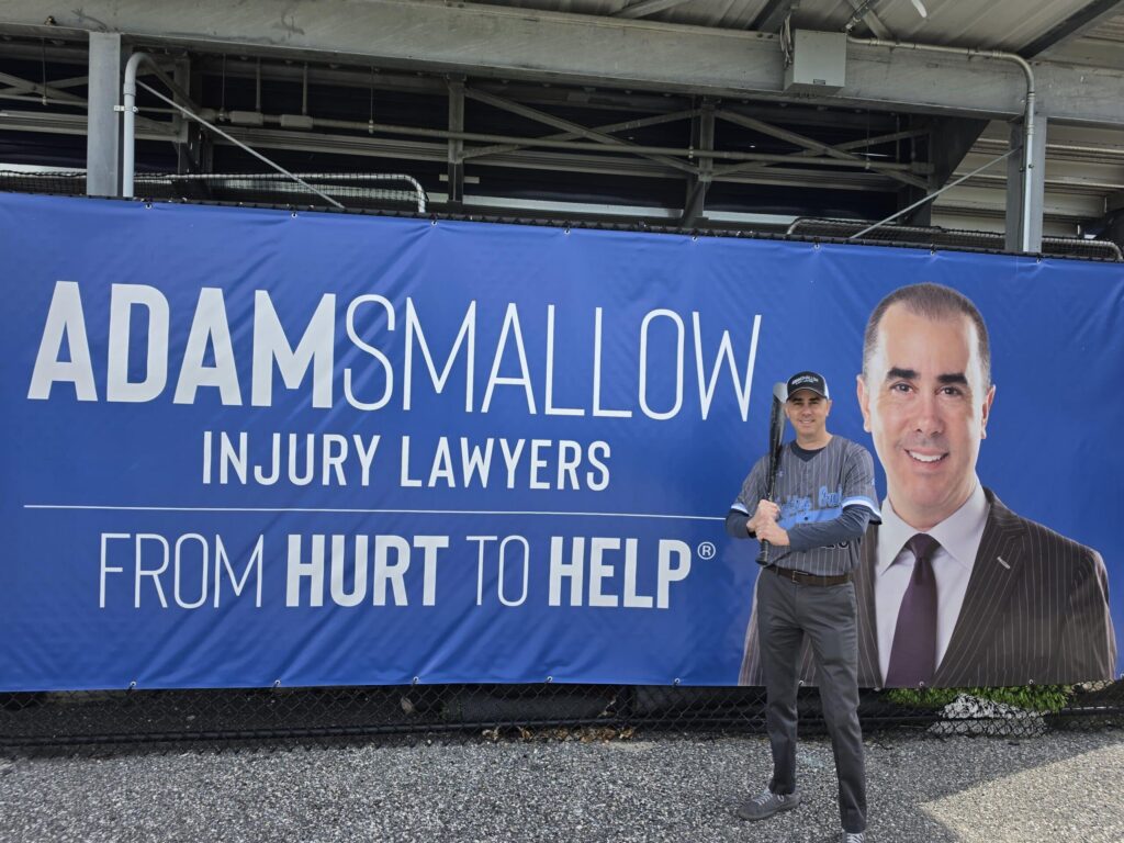 Adam Smallow standing in front of his firm's board